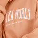 Osaka women sweater in peach with logo in white. Front detail logo view