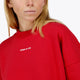 Woman wearing the Osaka women sweater in red with logo in white. Front detail logo view