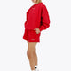 Woman wearing the Osaka women sweater in red with logo in white. Front / side view