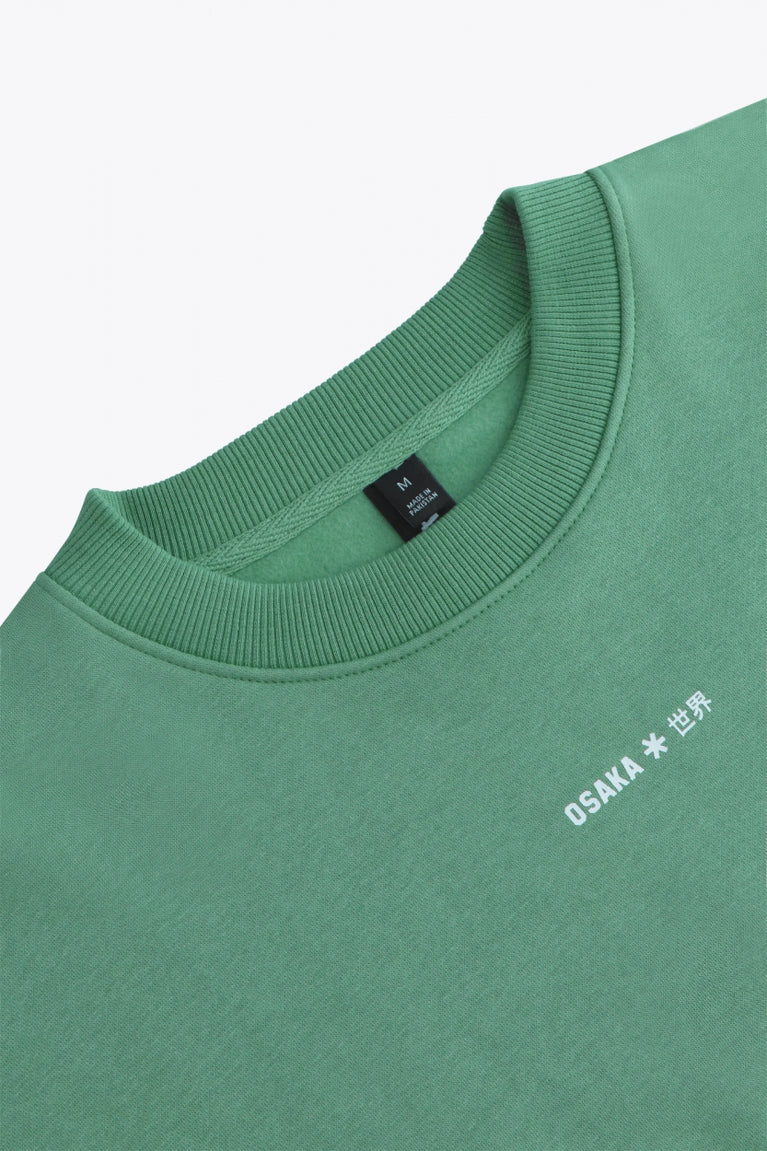 Osaka women sweater in green with logo in white. Front flatlay detail neckview