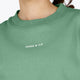 Osaka women sweater in green with logo in white. Front detail logo view