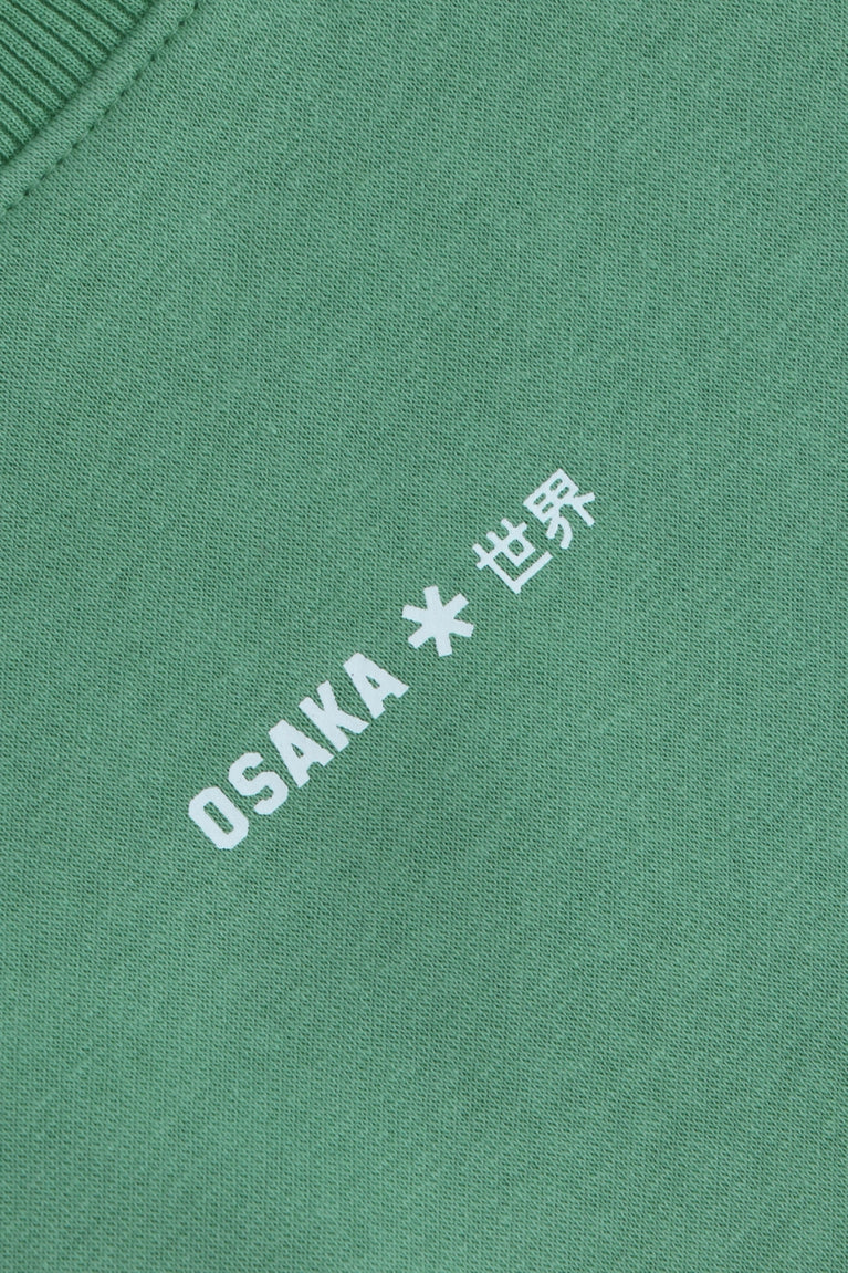 Osaka women sweater in green with logo in white. Front detail logo view