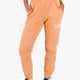 Woman wearing the Osaka women sweatpants in peach with logo in white. Front view