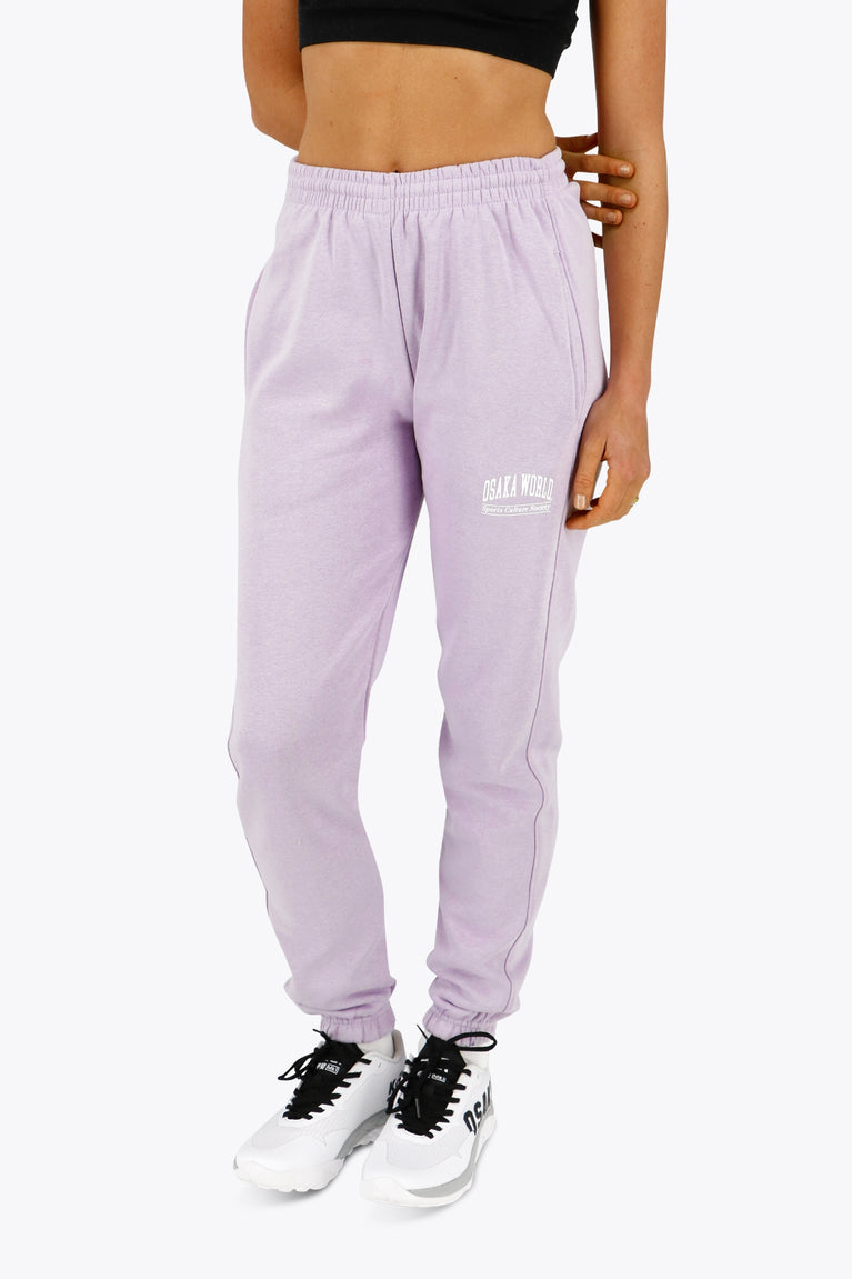 Woman wearing the Osaka women sweatpants in light purple with logo in white. Front view