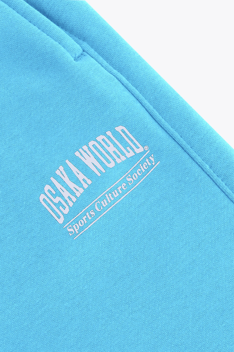 Osaka women sweatpants in light blue with logo in white. Front flatlay detail logo view
