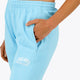 Woman wearing the Osaka women sweatpants in light blue with logo in white. Front detail logo view