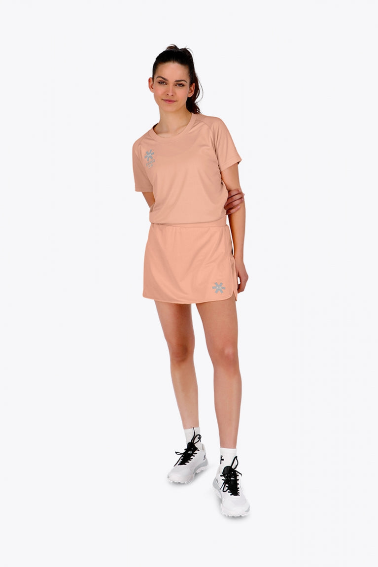 Woman wearing the Osaka women tee short sleeve in peach with logo in grey. Front view