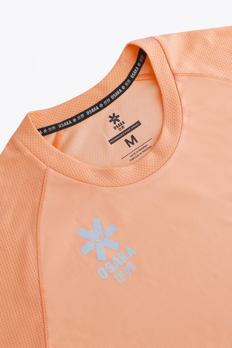 Osaka women tee short sleeve in peach with logo in grey. Front flatlay detail view