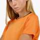 Woman wearing the Osaka women tee short sleeve in orange with logo in grey. Front detail view