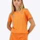 Woman wearing the Osaka women tee short sleeve in orange with logo in grey. Front view