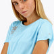 Woman wearing the Osaka women tee short sleeve in light blue with logo in grey. Front view