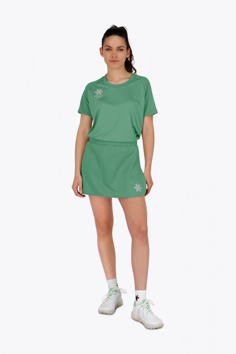 Woman wearing the Osaka women tee short sleeve in green with logo in grey. Front view