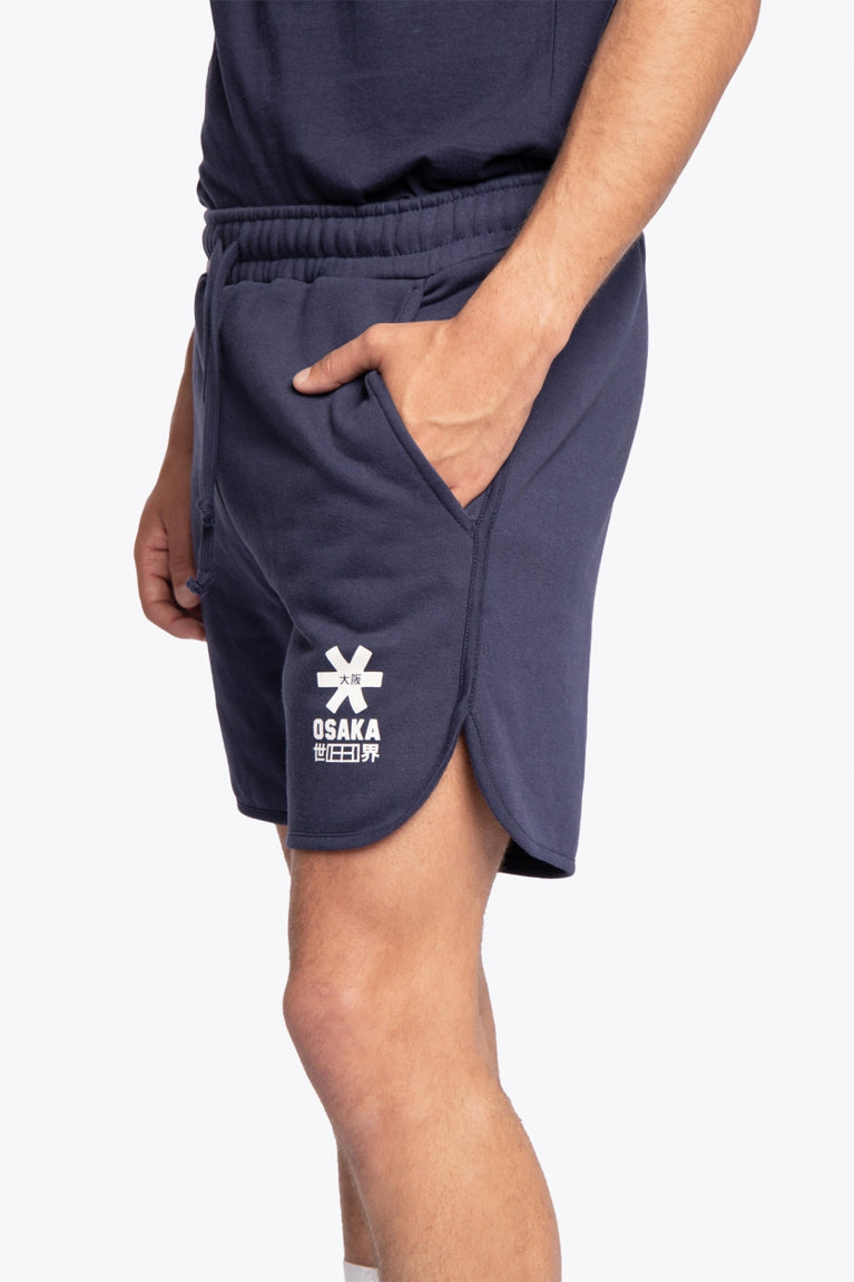 Man wearing the Osaka court classic short in navy with white logo. Side view