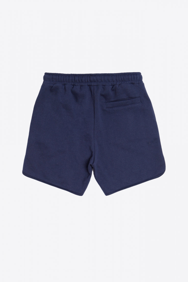 Man wearing the Osaka court classic short in navy with white logo. Back view