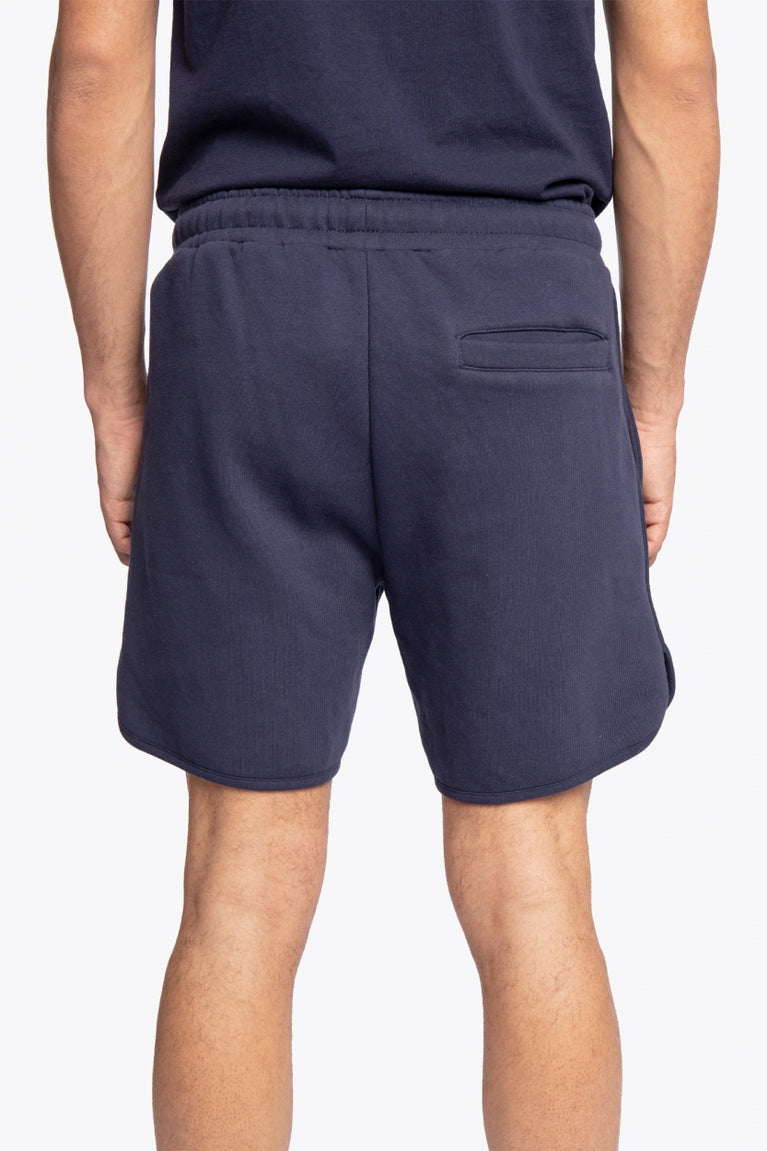 Man wearing the Osaka court classic short in navy with white logo. Back view
