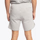 Man wearing the Osaka Men padel shorts in grey with green logo on it. Back view