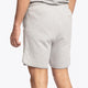 Man wearing the Osaka Men padel shorts in grey with green logo on it. Back / side view