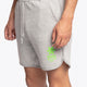 Man wearing the Osaka Men padel shorts in grey with green logo on it. Front / side view