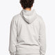 Man wearing the Osaka basic unisex hoodie in grey with green logo on it. Back view