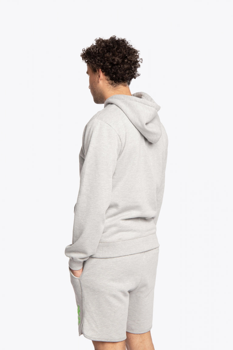Man wearing the Osaka basic unisex hoodie in grey with green logo on it. Back / side view