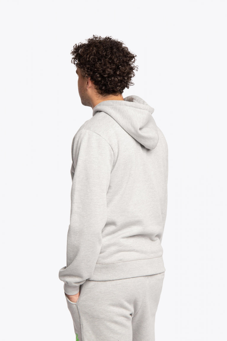 Man wearing the Osaka basic unisex hoodie in grey with green logo on it. Back side view