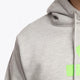 the Osaka basic unisex hoodie in grey with green logo on it. Front detail shoulder view