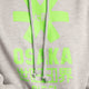 the Osaka basic unisex hoodie in grey with green logo on it. Front detail logo view