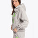Woman wearing the Osaka basic unisex hoodie in grey with green logo on it. Side view