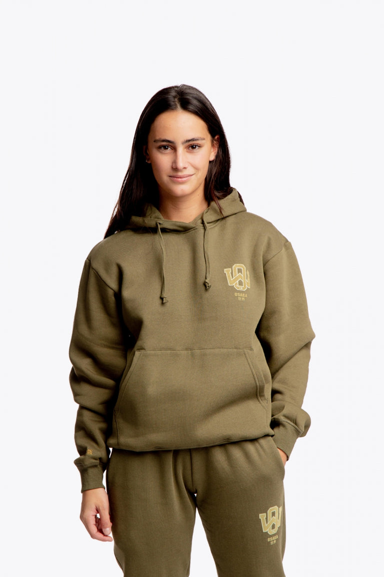 Girl wearing the Osaka unisex hoodie in army green with college initials in yellow. Front view