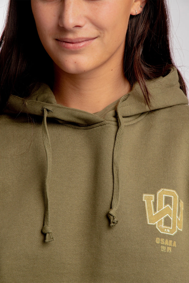 Girl wearing the Osaka unisex hoodie in army green with college initials in yellow. Front detail logo view