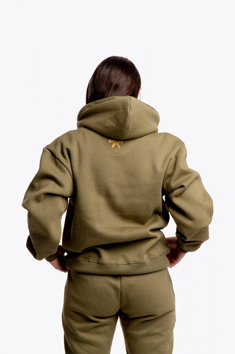 Girl wearing the Osaka unisex hoodie in army green with college initials in yellow. Back view