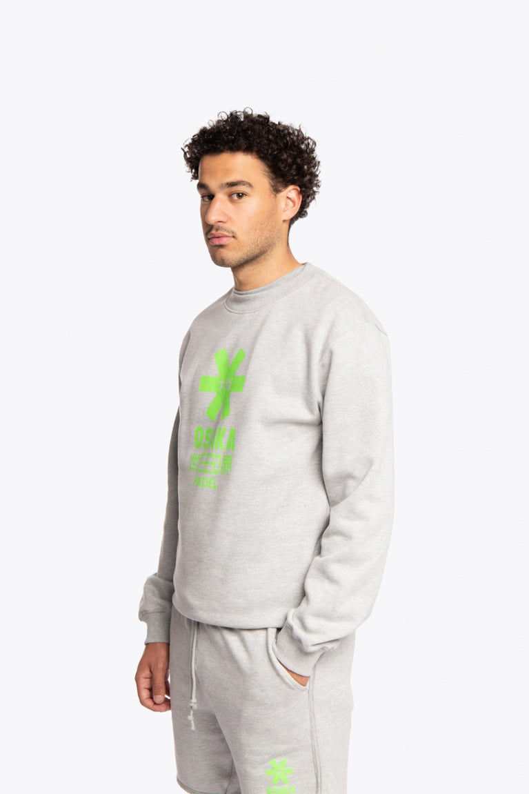 Man wearing the Osaka grey unisex sweater with green logo. Side / front view