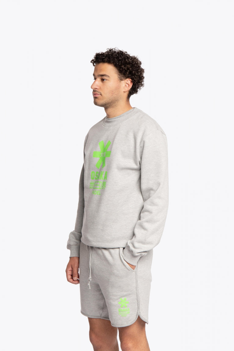 Man wearing the Osaka grey unisex sweater with green logo. Side / front view