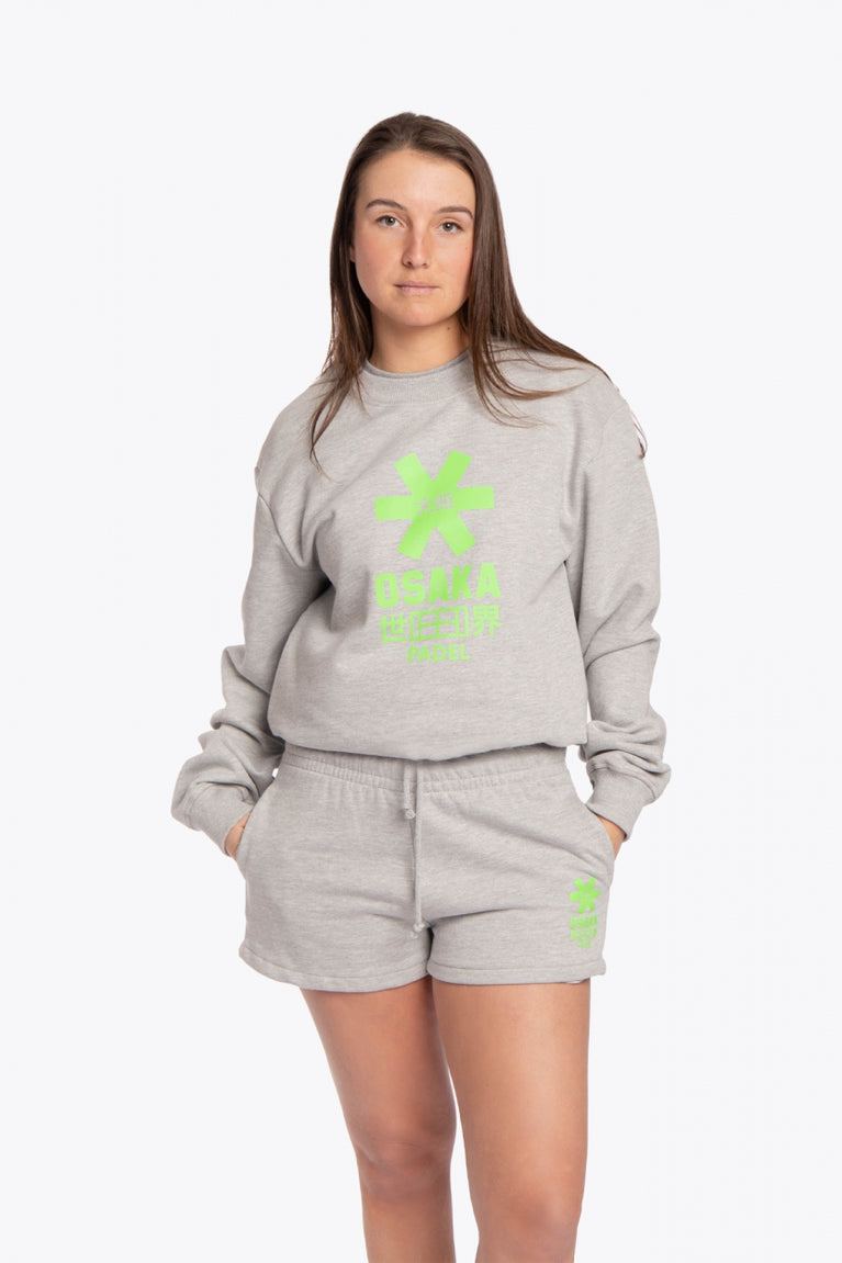 Woman wearing the Osaka grey unisex sweater with green logo. Front view