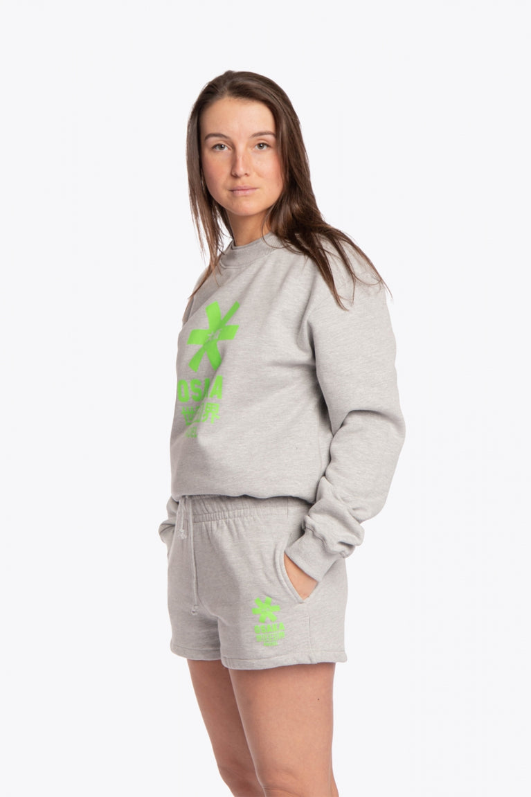 Woman wearing the Osaka grey unisex sweater with green logo. Front / side view