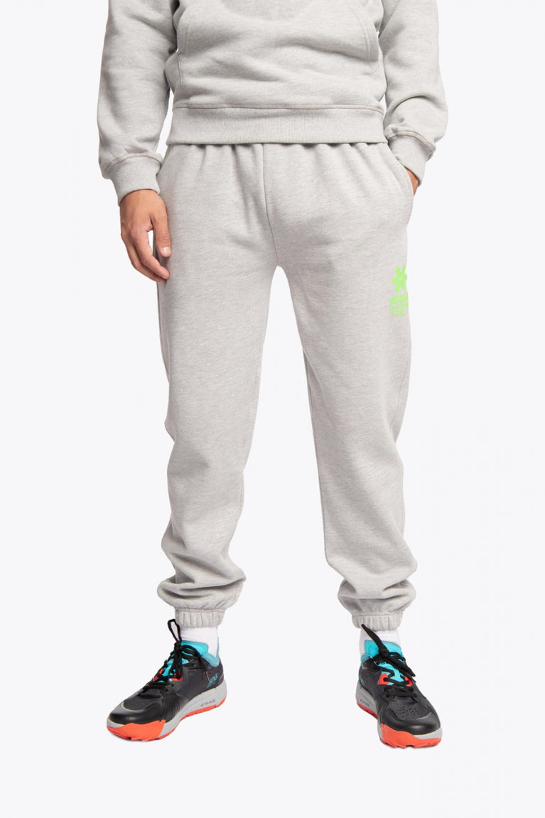 Men wearing the Osaka unisex sweatpants in heather grey with logo in green. Front view