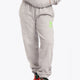 Model wearing the Osaka unisex sweatpants in heather grey with logo in green. Front view