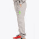 Model wearing the Osaka unisex sweatpants in heather grey with logo in green. Side view