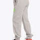 Model wearing the Osaka unisex sweatpants in heather grey with logo in green. Side back view