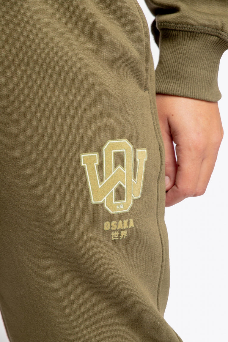 Osaka unisex sweatpants in army green with logo in yellow. Detail logo view
