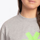 Woman wearing the Osaka unisex tee in heather grey with green logo. Detail neck view