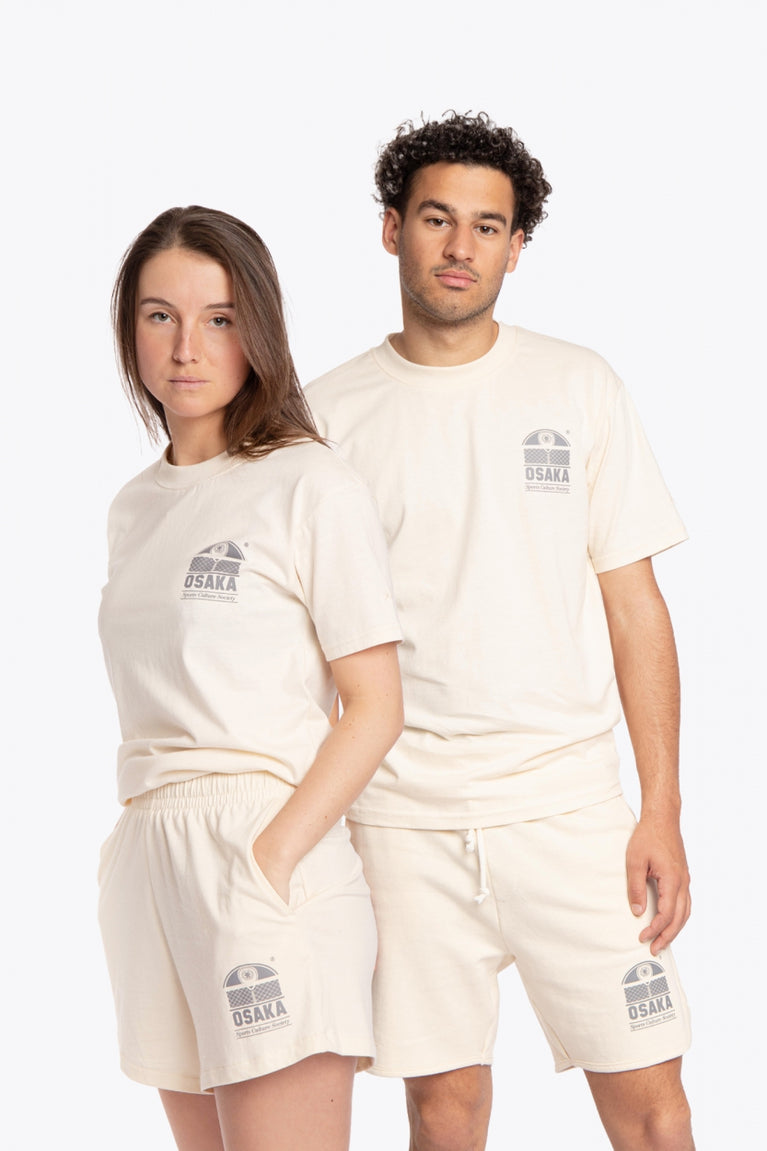 Man and woman wearing the Osaka unisex tee in cream with logo in grey. Front view