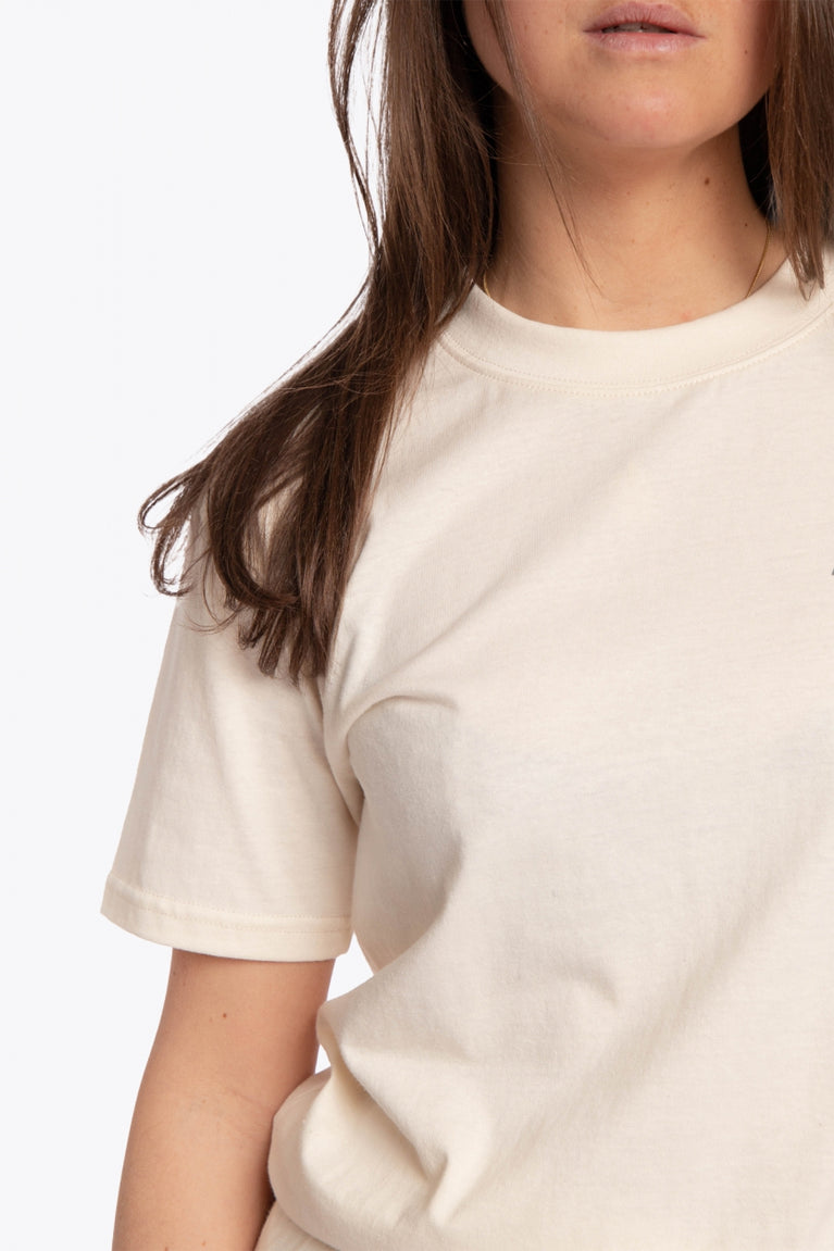 Woman wearing the Osaka unisex tee in cream with logo in grey. Detail sleeve view