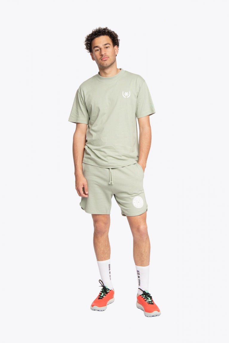 Man wearing the Osaka unisex tee in iceberg green with white logo. Front view