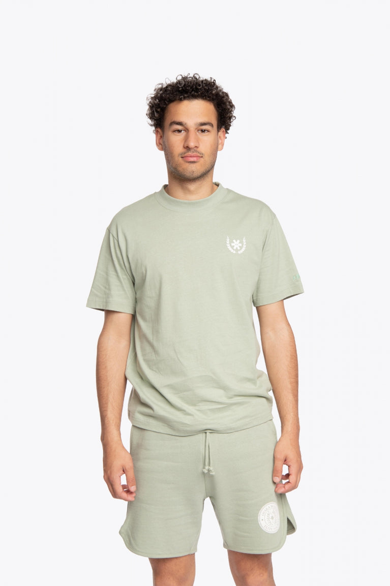 Man wearing the Osaka unisex tee in iceberg green with white logo. Front view