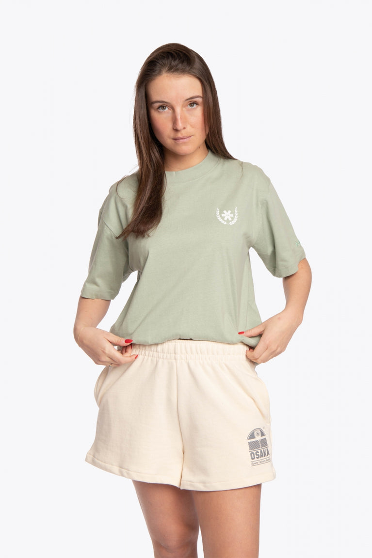 Woman wearing the Osaka unisex tee in iceberg green with white logo. Front view