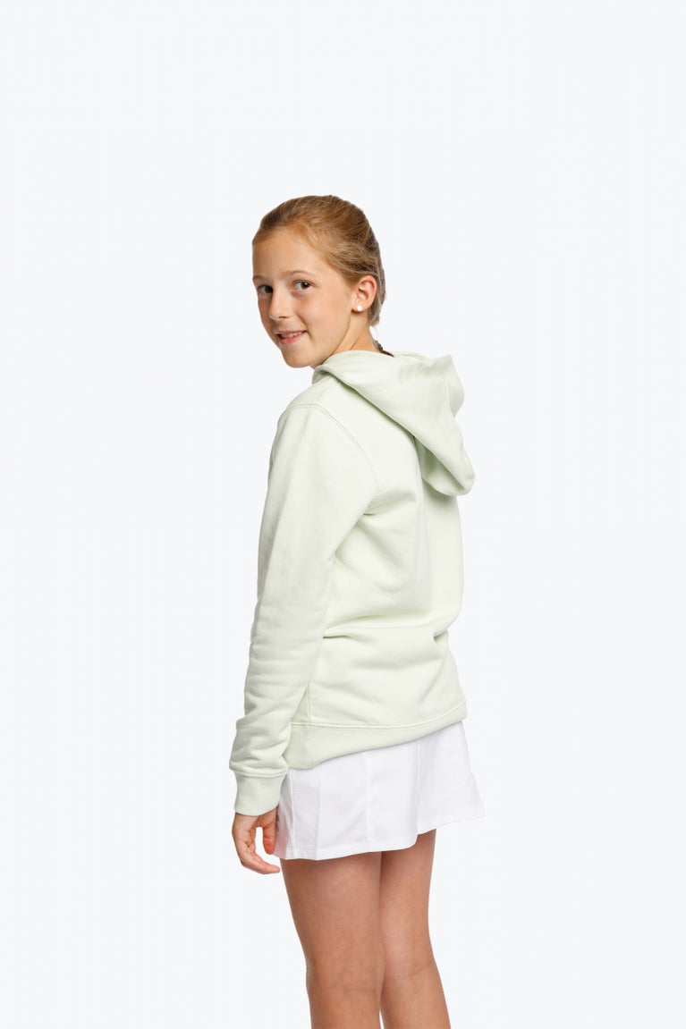 Girl wearing the Osaka kids hoodie in mint green with logo in college letters in white. Back view
