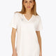 Woman wearing the Osaka women v-neck tech dress in white with logo in grey. Front view