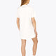 Woman wearing the Osaka women v-neck tech dress in white with logo in grey. Back view