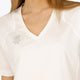 Woman wearing the Osaka women v-neck tech dress in white with logo in grey. Front detail neck view